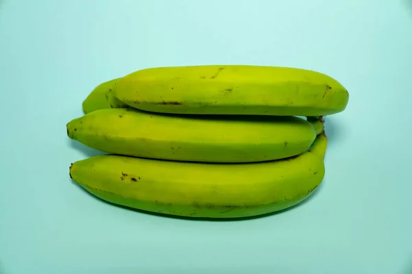 Un mucchio di banane acide su uno sfondo blu. — Foto Stock