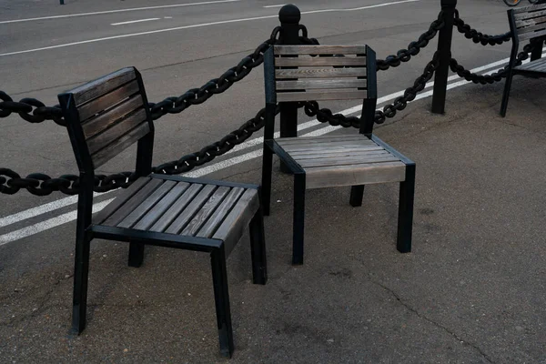 Two wooden chairs on the asphalt embankment. — Stock Photo, Image