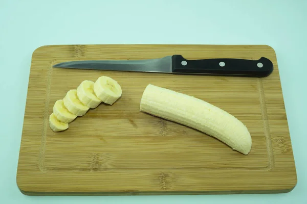 Banan på en skärbräda med kökskniv. — Stockfoto