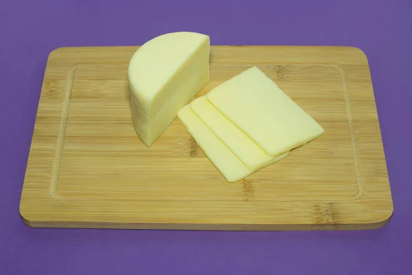 Head of cheese on a wooden cutting board with chopped pieces. — Stock Photo, Image