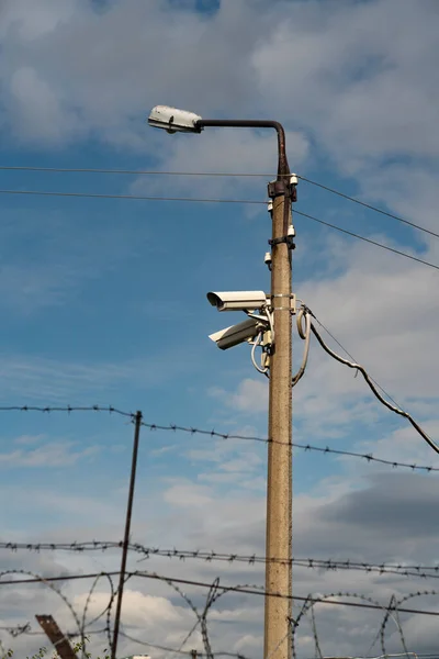 Betonlaterne mit CCTV-Kameras gegen den blauen Himmel. — Stockfoto