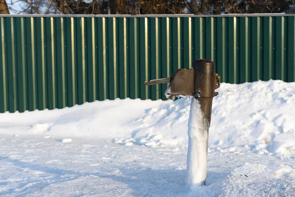 Vecchia colonna d'acqua in inverno sulla neve. — Foto Stock