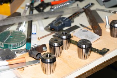 Masanın üzerinde bir Collet değirmen makinesi ve bir alet..