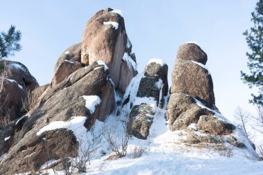 Nadir, kısmen yıpranmış karlı kahverengi bir kaya..