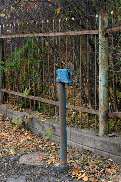 Стара водяна колона з синім краном на вулиці . — стокове фото