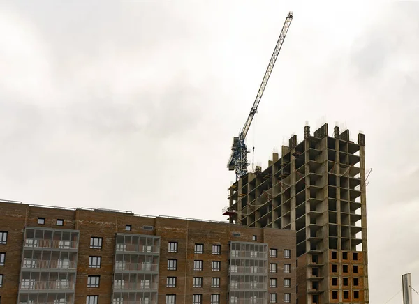 Construcción de un edificio de varios pisos con una grúa. — Foto de Stock