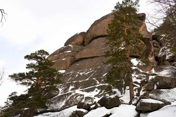 Roche massive partiellement recouverte de neige dans le parc. — Photo