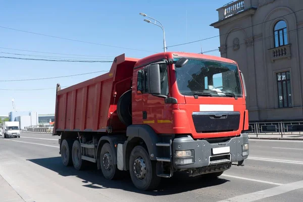 Camião vermelho na encruzilhada da cidade. Equipamento de transporte de mercadorias na cidade. — Fotografia de Stock