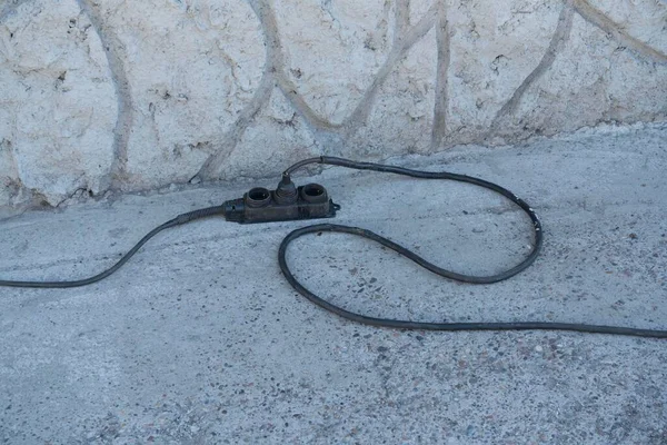 Siyah elektrik şeridi siyah kabloyla kaldırımda.. — Stok fotoğraf