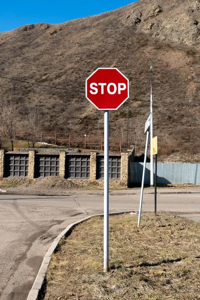 Sinal de estrada de parada vermelha na esquina de um cruzamento. — Fotografia de Stock