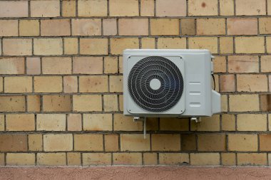 Tuğla duvardaki beyaz klima soğutucusu..