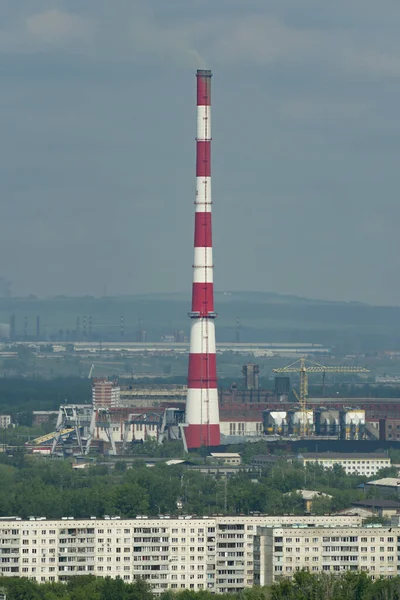 Una enorme chimenea de ladrillo rojo-blanco en el centro de una ciudad industrial. — Foto de Stock