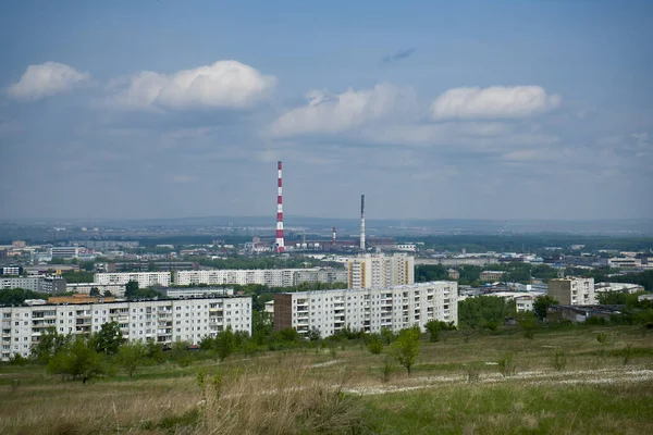 Una ciudad industrial en el horizonte sobre el telón de fondo de un cielo nublado. — Foto de Stock