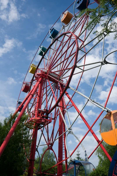 Ferris wiel tegen de achtergrond van een blauwe lucht met wolken. — Stockfoto