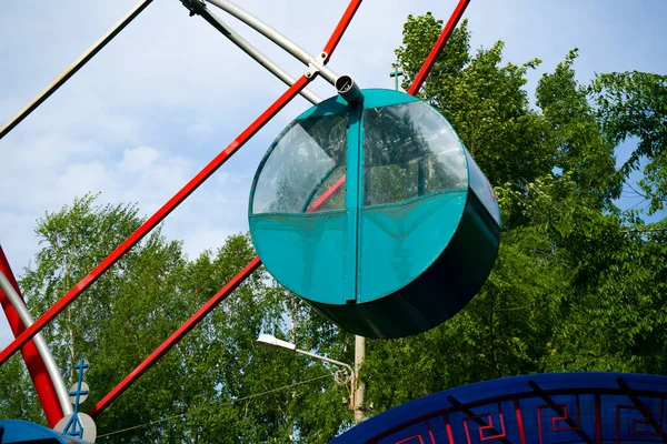 Groene cabine van het ronde reuzenrad tegen de achtergrond van de blauwe lucht. — Stockfoto