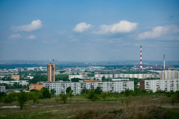 Una ciudad industrial en el horizonte sobre el telón de fondo de un cielo nublado. — Foto de Stock