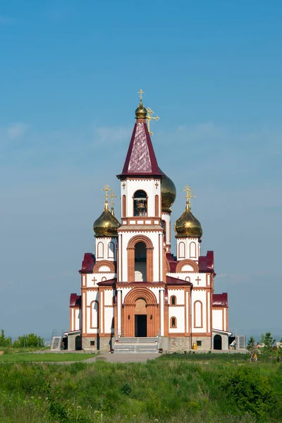 Church with golden domes against a blue sky with white clouds. — Stock Photo, Image