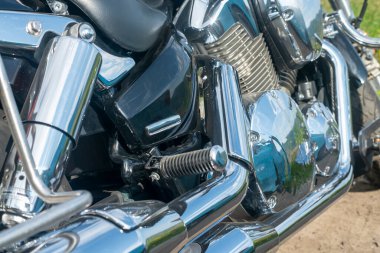 Krom motor parçaları arasında siyah motosiklet ayaklığı.