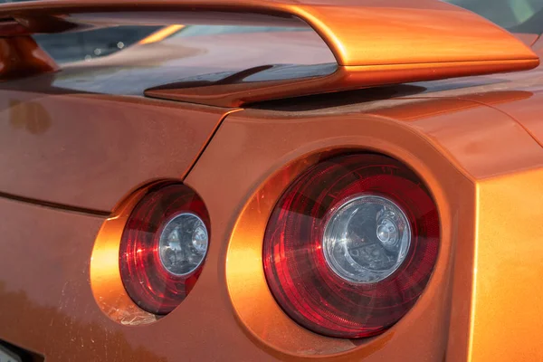 Luzes traseiras vermelhas parar sinais para um carro esportivo laranja. — Fotografia de Stock