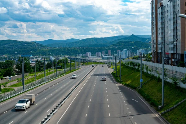 Autostrada wielopasmowa z pasem dzielącym. Samochodowe drogi miejskie w letni dzień. — Zdjęcie stockowe