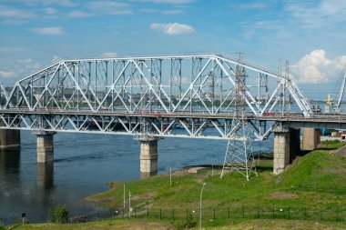 Endüstriyel bir şehirde nehir üzerindeki bir demiryolu köprüsünün kemeri..