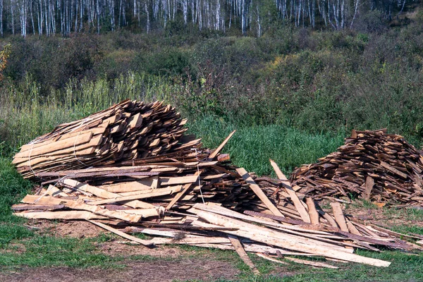 Bois stocké en plein air sur l'herbe verte. — Photo