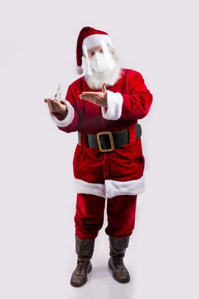 Papai Noel Usando Uma Máscara Apontando Garrafa Gel Hidroalcoólico Fundo — Fotografia de Stock