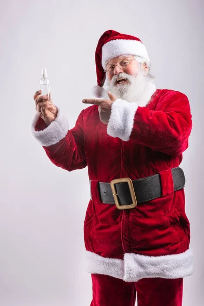 Święty Mikołaj Wskazując Butelką Żel Hydroalkoholowy Białym Tle — Zdjęcie stockowe