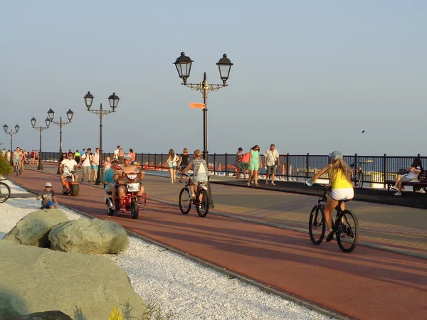 As pessoas andam de bicicleta no passeio marítimo, resort Sochi, Rússia, 4 de agosto de 2016 — Fotografia de Stock