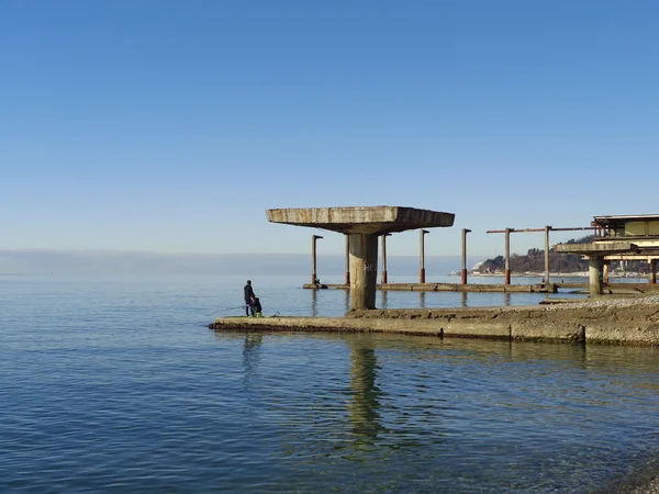Морская рыбалка с пирса в солнечный день, голубое море и небо — стоковое фото