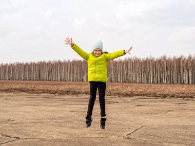 Parlak ceketli neşeli kız baharda ormanın arka planında