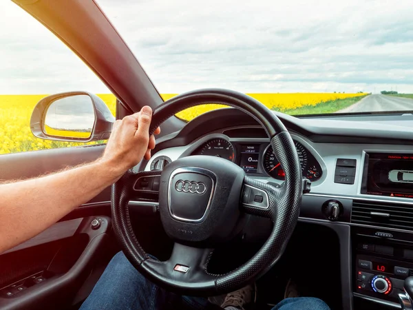 stock image GOMEL, BELARUS - May 24, 2020: male hands hold the steering wheel in new, black, stylish interior of the car audi a6 c6 s-line