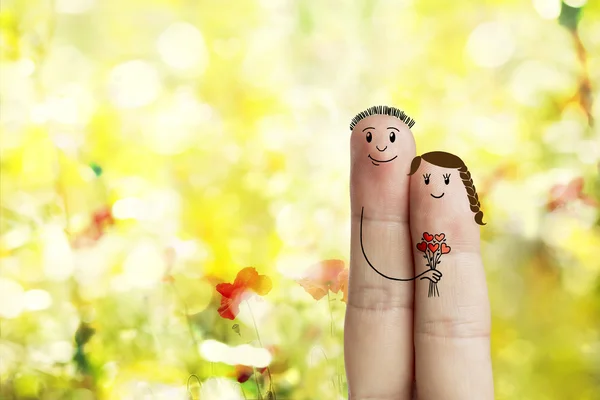 L'art du doigt d'un couple heureux. L'homme donne un bouquet de cœurs rouges. Image de stock — Photo