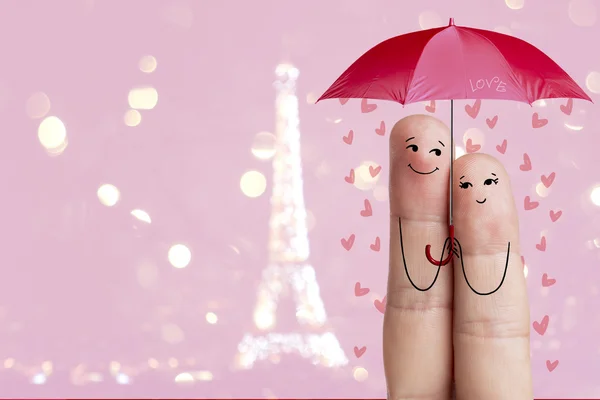 Arte de dedos. Los amantes abrazan y sostienen paraguas rojo contra el fondo de la torre Eiffel. París. Imagen de stock — Foto de Stock