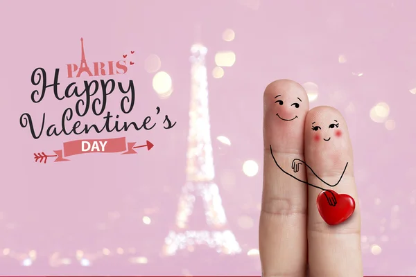 Finger art. Lovers are embracing and holding red heart against the background оf the Eiffel tower. Stock Image — Stock Photo, Image