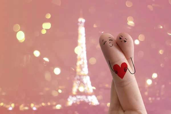 Finger art. Lovers are embracing and holding red heart against the background оf the Eiffel tower. — Stock Photo, Image