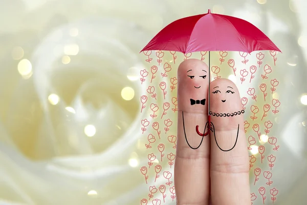 Conceptual finger art. Lovers is embracing and holding red umbrella with falling flowers. Stock Image — Stock Photo, Image