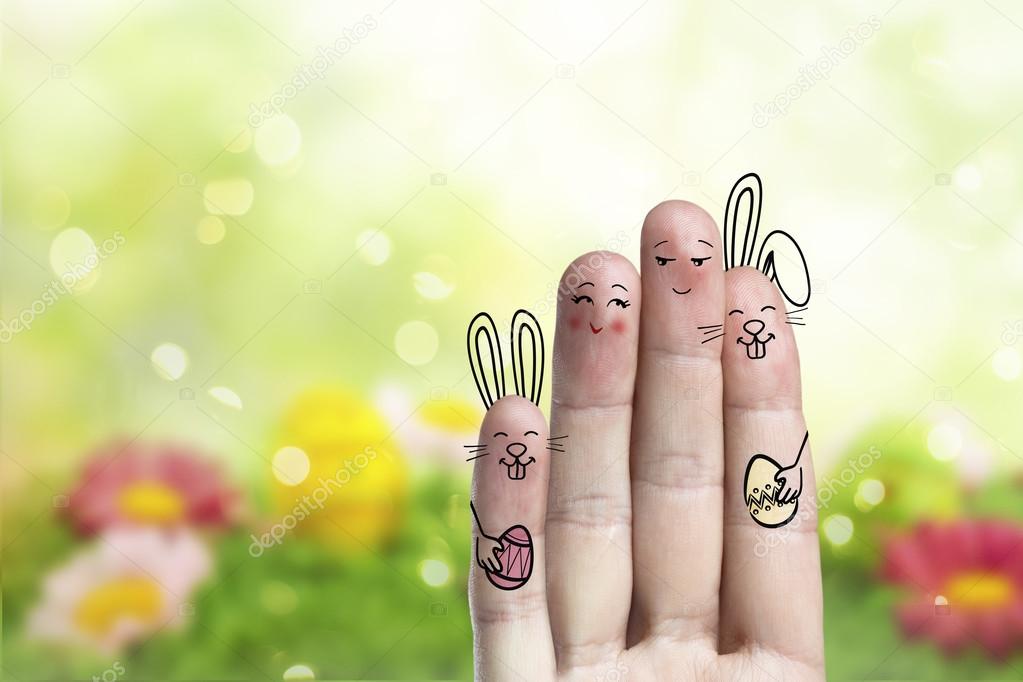 Conceptual easter finger art. Couple with a two bunnys are holding painted eggs