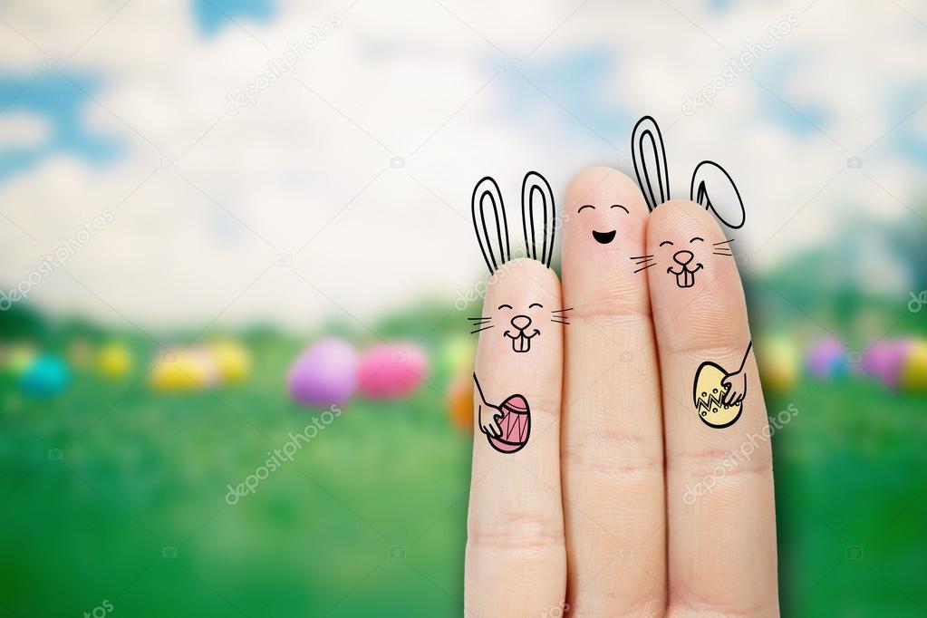 Conceptual easter finger art. Person with a two bunnys is holding eggs