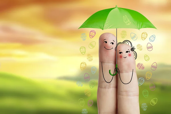 Conceptuele Pasen vinger art. Paar houdt groene paraplu met dalende eieren. Stock beeld — Stockfoto