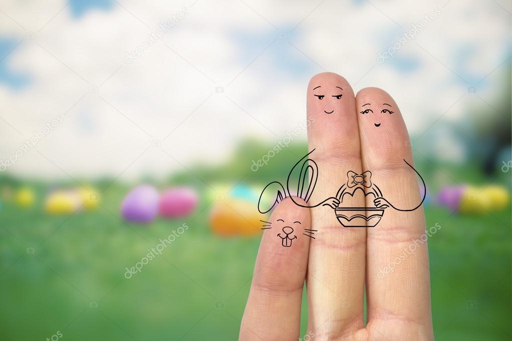 Conceptual easter finger art. Couple with bunny are holding basket with painted eggs