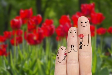 Conceptual family finger art. Father and daughter are giving flowers his mother. Stock Image.