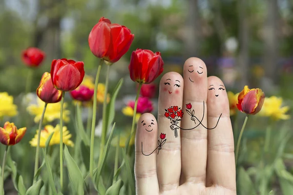 Konzeptionelle Familienfingerkunst. Vater, Sohn und Tochter schenken ihrer Mutter Blumen. — Stockfoto