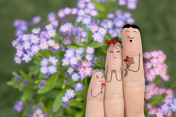 Konzeptionelle Familienfingerkunst. Vater und Sohn überreichen seiner Mutter Blumen. Archivbild — Stockfoto