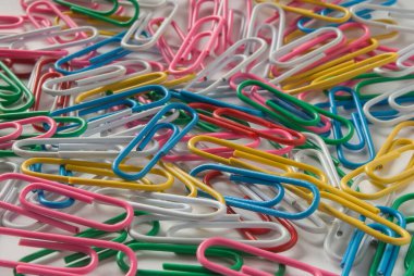 Birçok renkli ataç beyaz kağıda saçılmış.