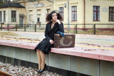 Tren için boş demiryolu platformu üzerinde bekleyen kız