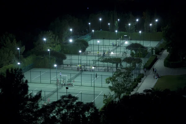 Jogando tênis à noite — Fotografia de Stock