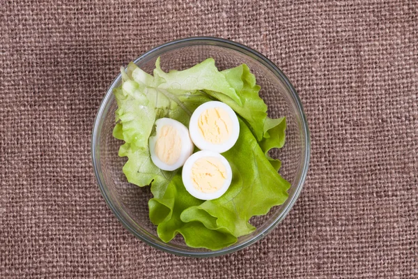 Cortar los huevos de codorniz y la lechuga en un bol — Foto de Stock