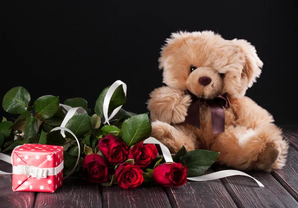 泰迪熊和卡在木头上的玫瑰花 — 图库照片