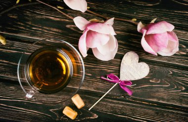 Fincan siyah çay ve çiçek Manolya ahşap kurullarında.